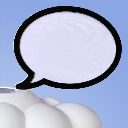 A white, cloud-shaped dry erase word bubble charm with a blank, speech bubble-like space in the center for writing, attached to a plant.