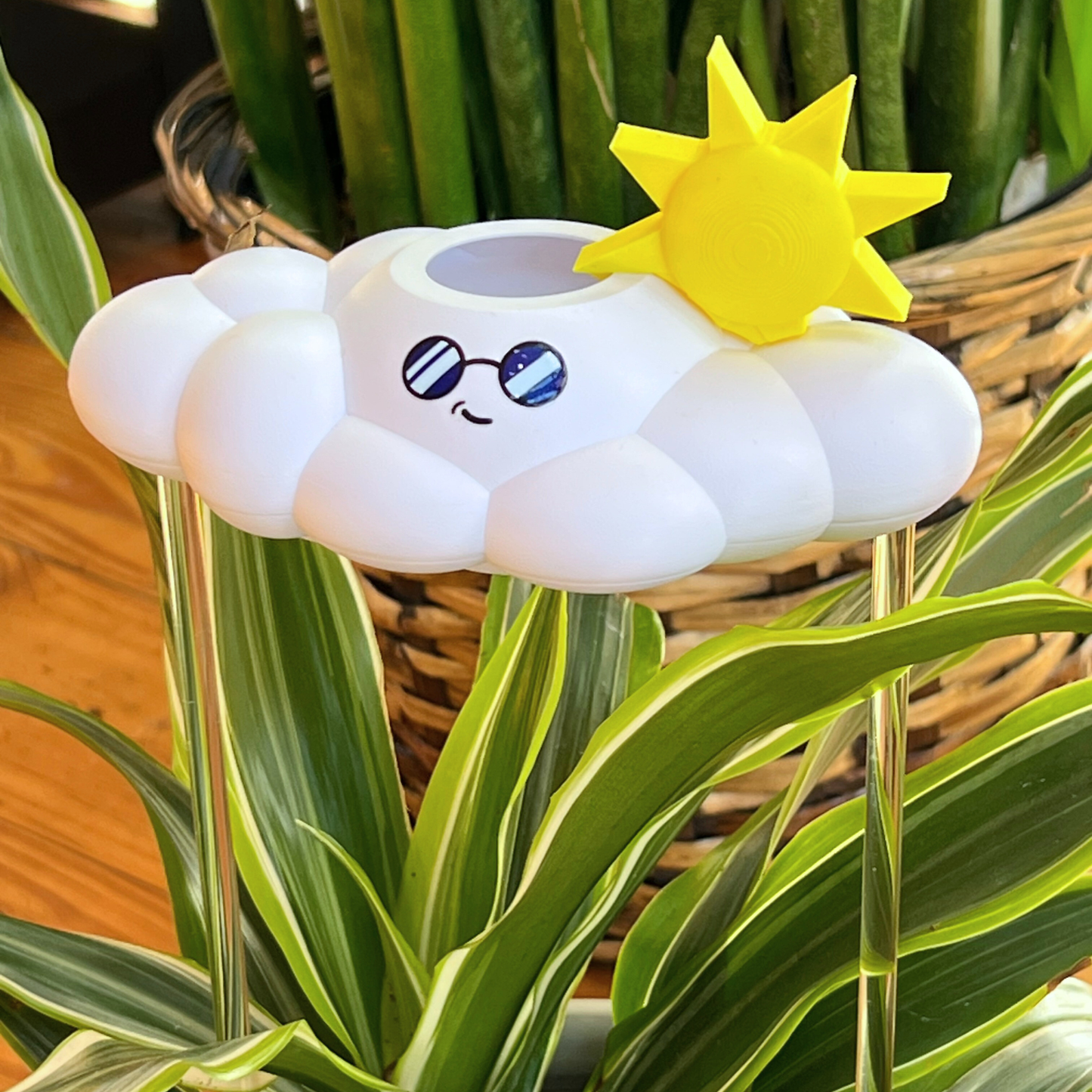 Cooper the Cloud with a sun charm on top, placed among plants