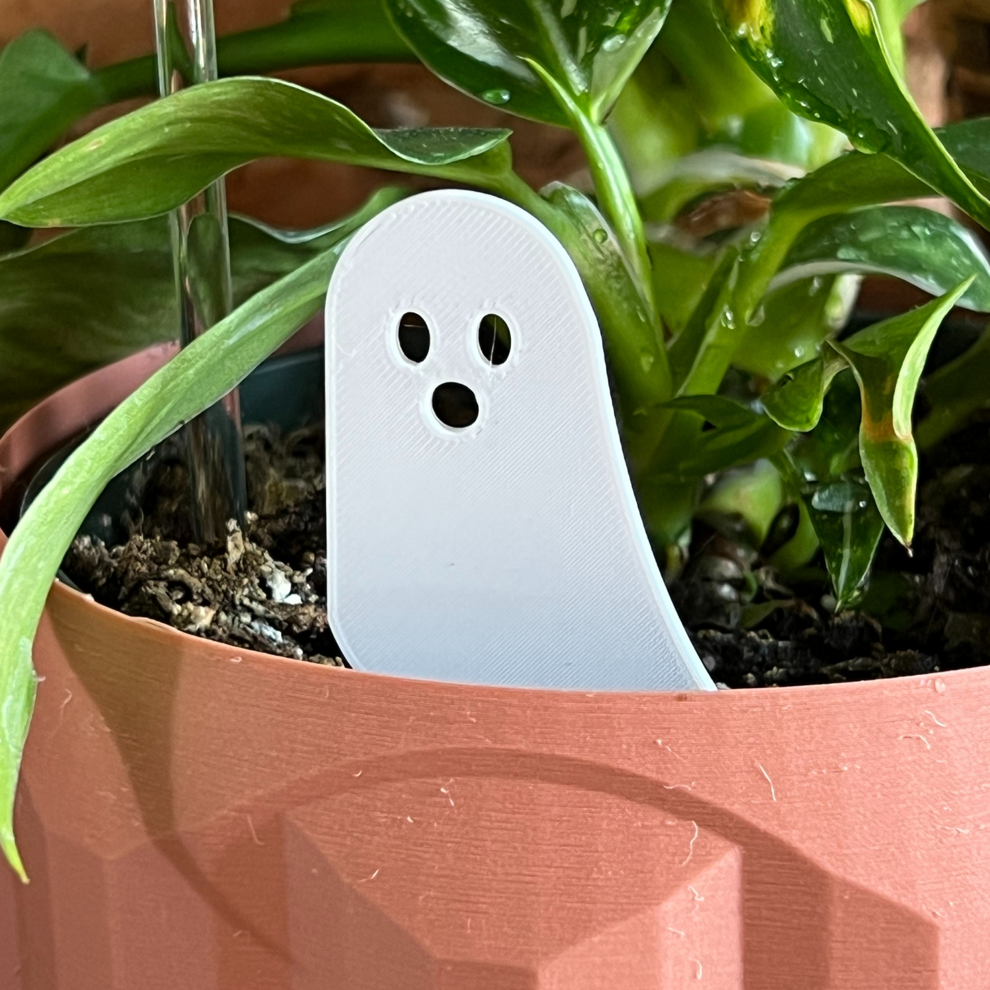 White ghost-shaped Plick in a potted plant