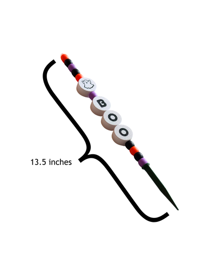 A Halloween-themed Plant Stake with white letter beads spelling 'BOO', a ghost bead, and orange, purple, and black spacer beads on a white background. A black bracket indicates a length of 13.5 inches.