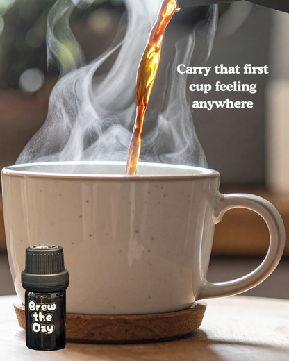 Steaming coffee being poured into a mug with 'Brew the Day' fragrance oil bottle.