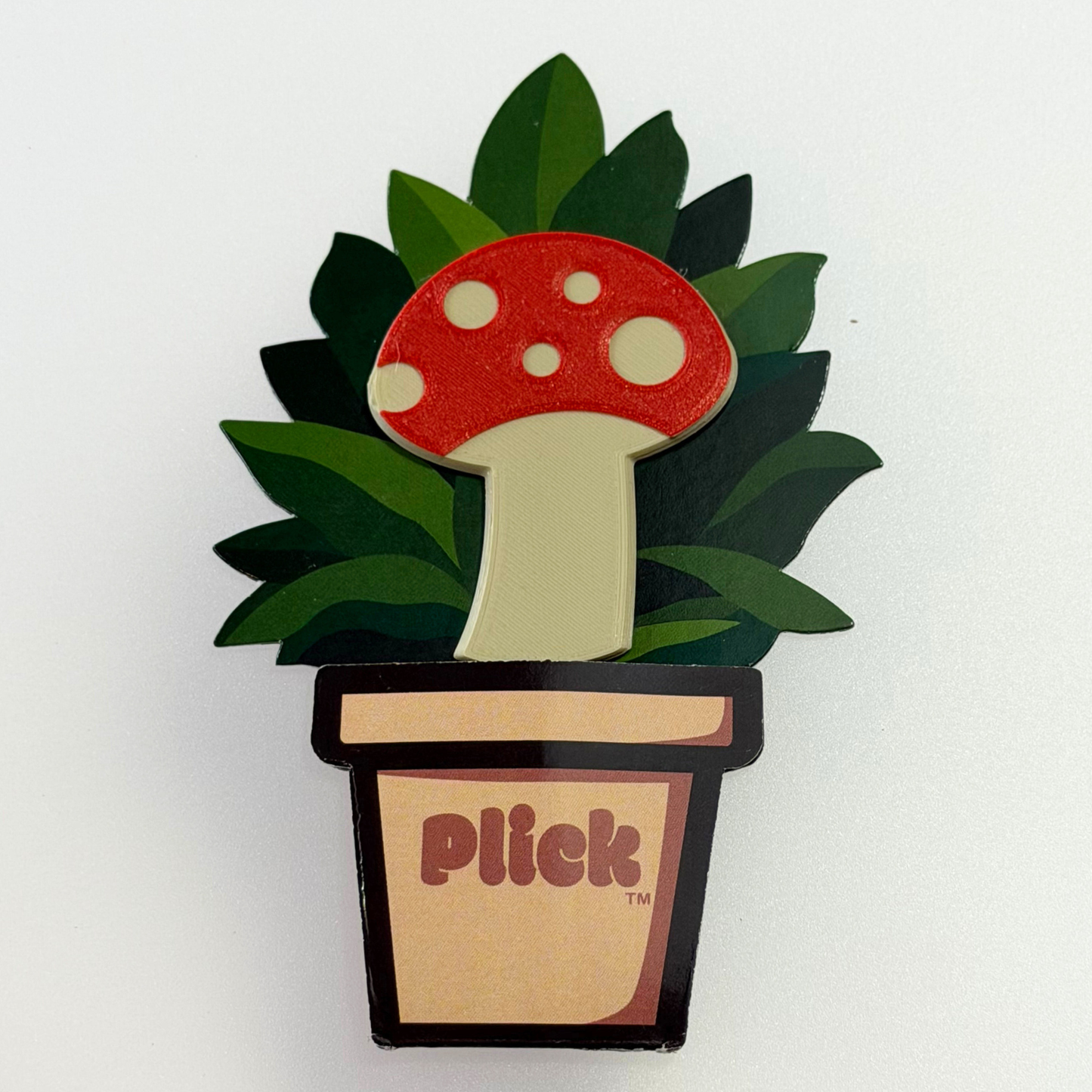 Mushroom-shaped plant decoration with 'Plick' branding on a white background