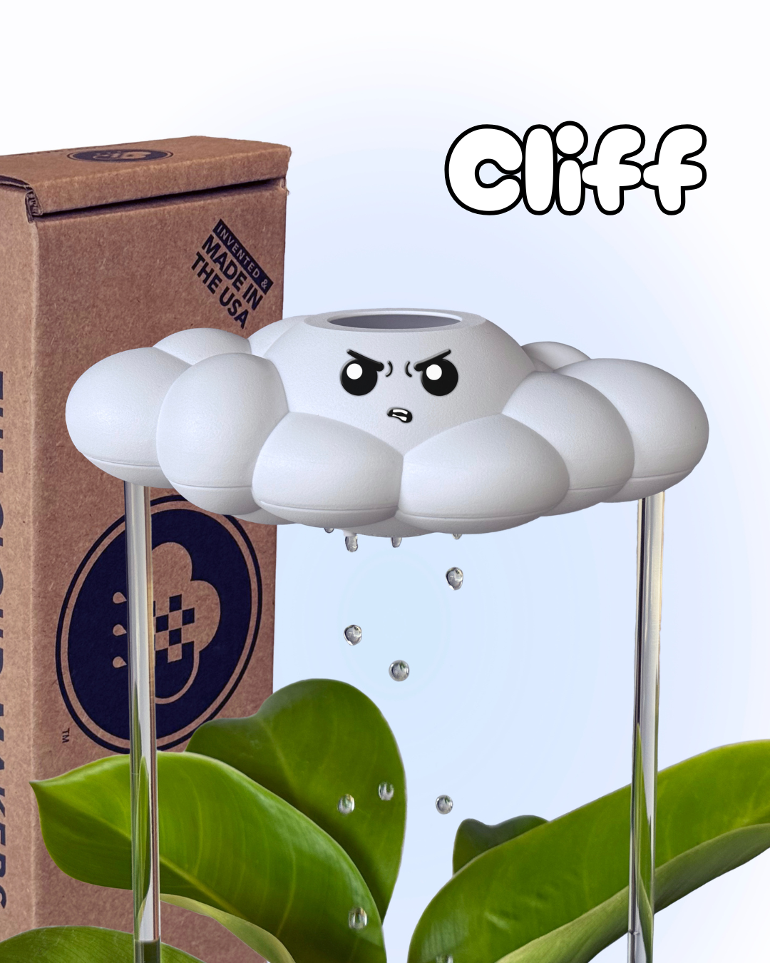 Cliff the Cloud in a plant next to a cardboard box with The Cloud Makers branding.