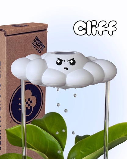 Cliff the Cloud in a plant next to a cardboard box with The Cloud Makers branding.