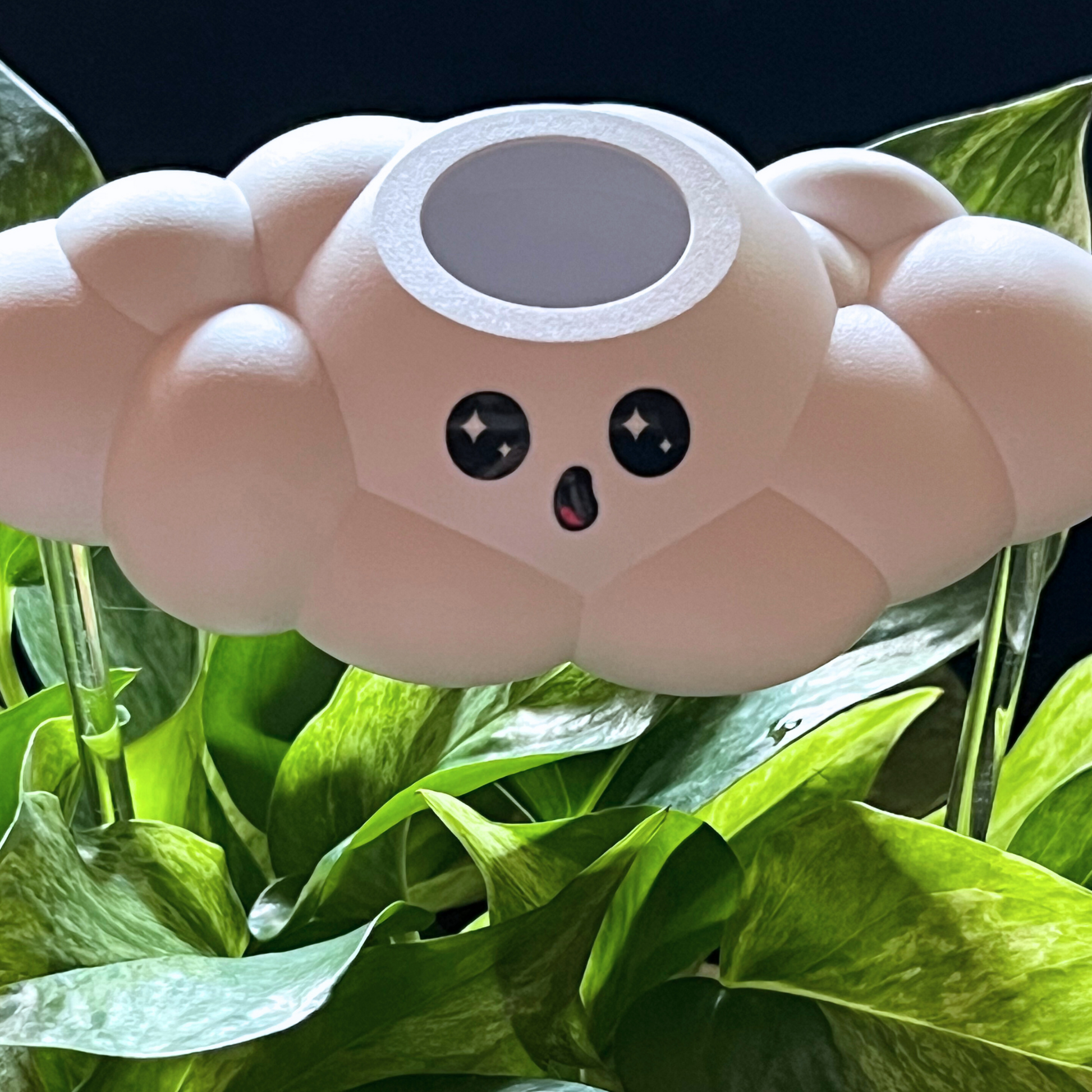 Cosmo the cloud surrounded by green leaves.