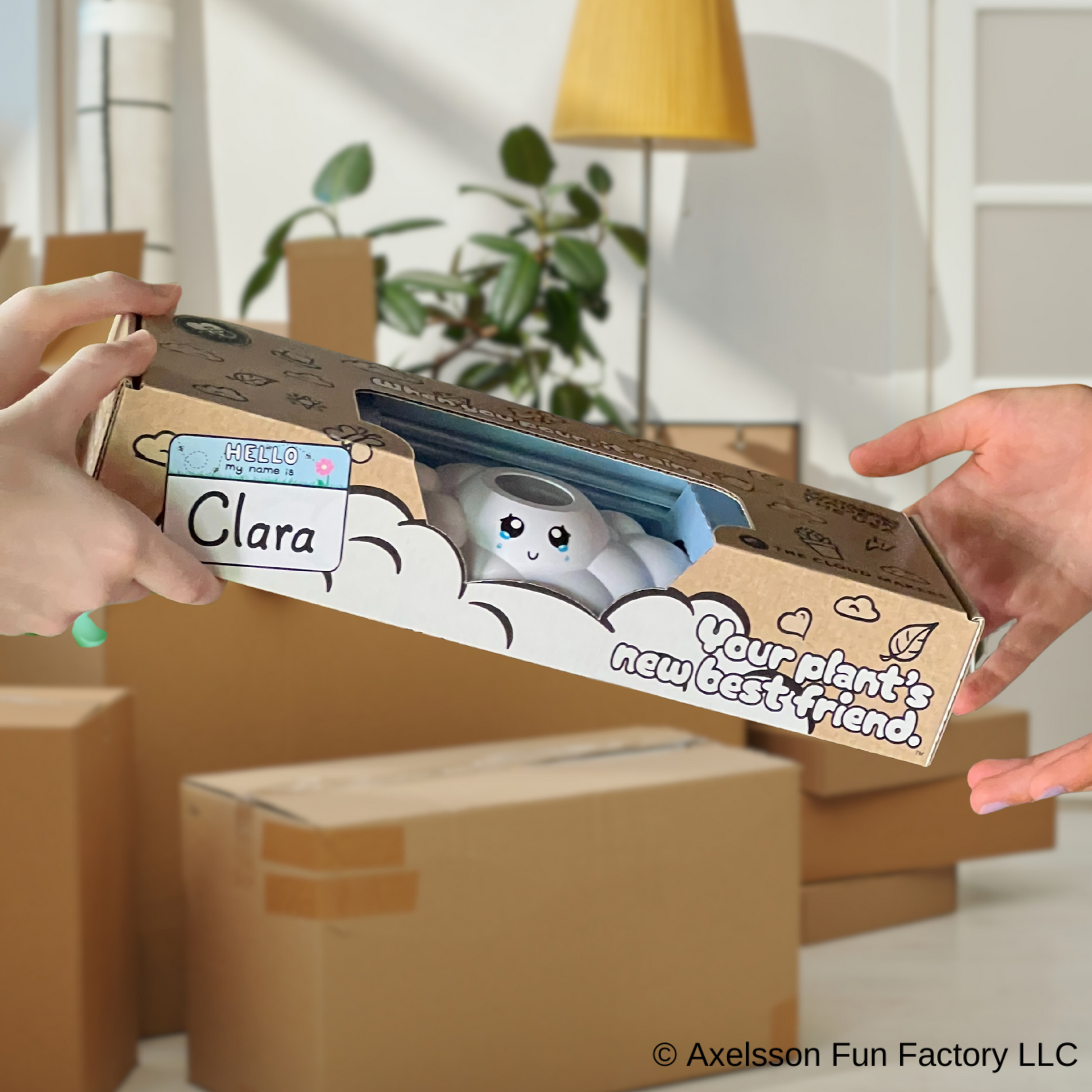 Clara the cloud in product packaging, held by two hands in a room setting.