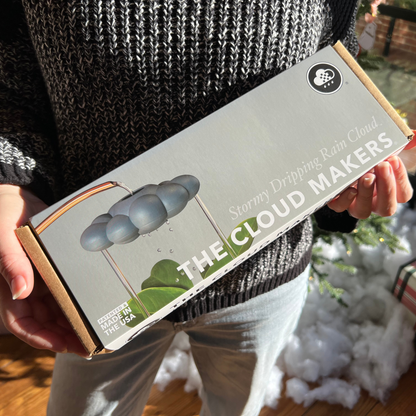 Person holding a box labeled 'The Cloud Makers' with a blurred background