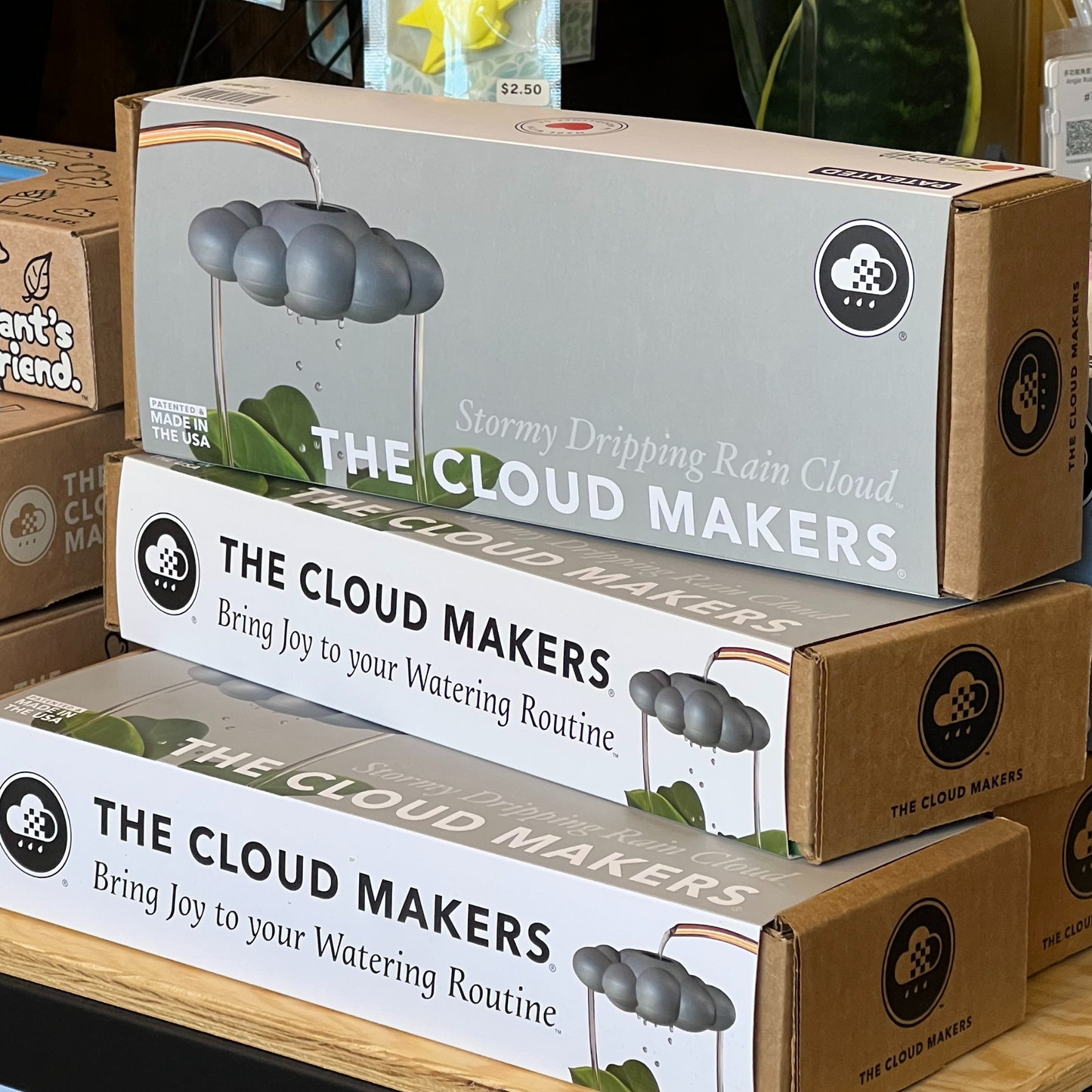 Multiple boxes of 'The Cloud Makers' product stacked on a table.