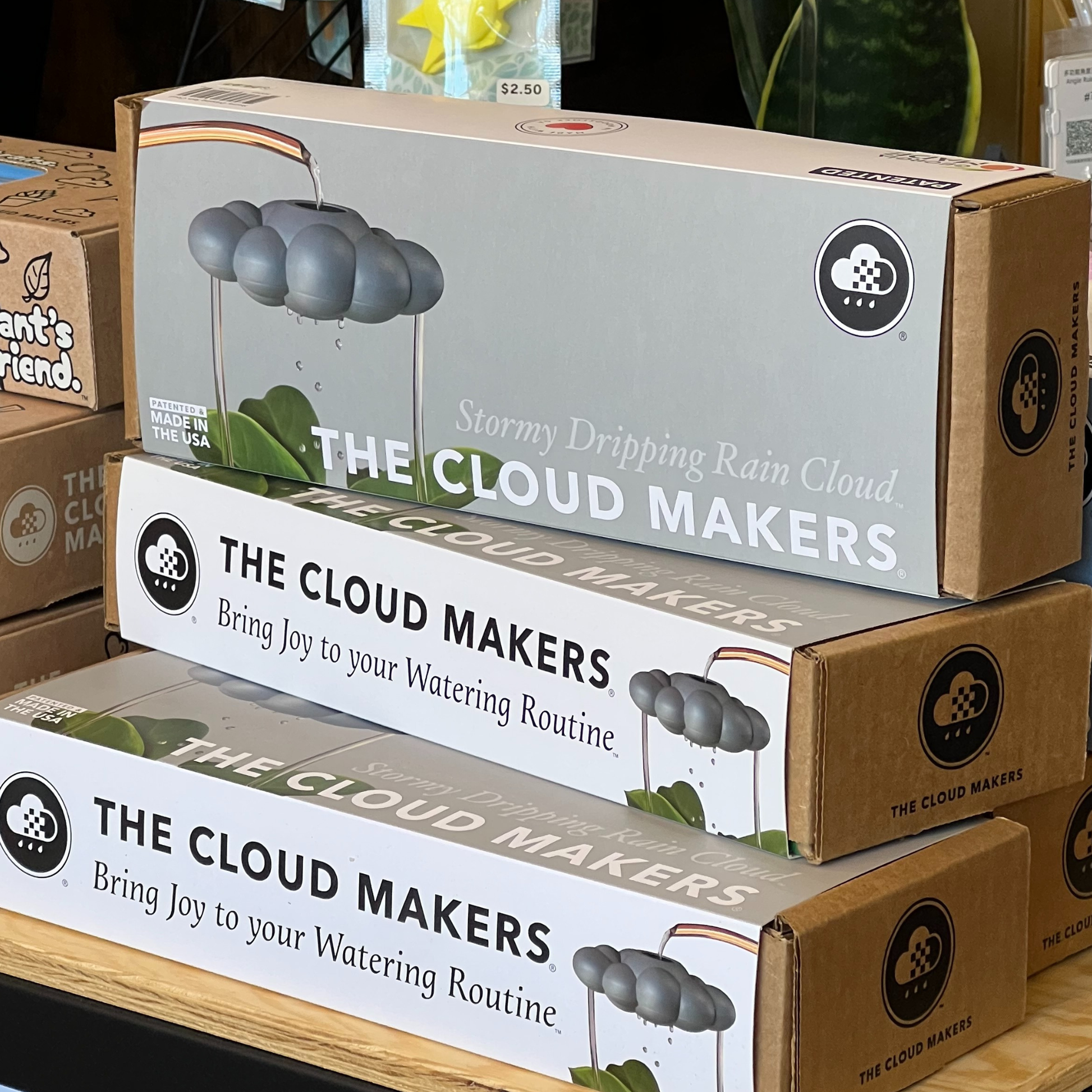 Multiple boxes of 'The Cloud Makers' product stacked on a table.